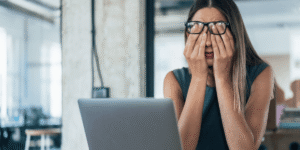 Colaboradora sofrendo por riscos psicossociais no trabalho - Qualitá Mais