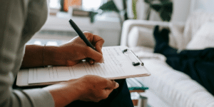 profissional fazendo anotações em prancheta - avaliação de riscos psicossociais - Qualitá Mais